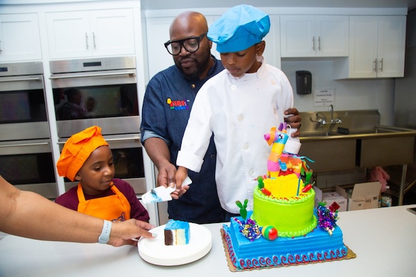 Photo of a kids chef cutting a piece of cake